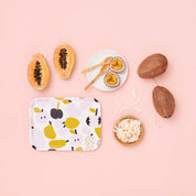 Olive green fruit-pattern birch veneer tray by Hannele Äijälä, 10.6" x 7.9" with coconuts, papayas, and a bowl of rice on a pink background.