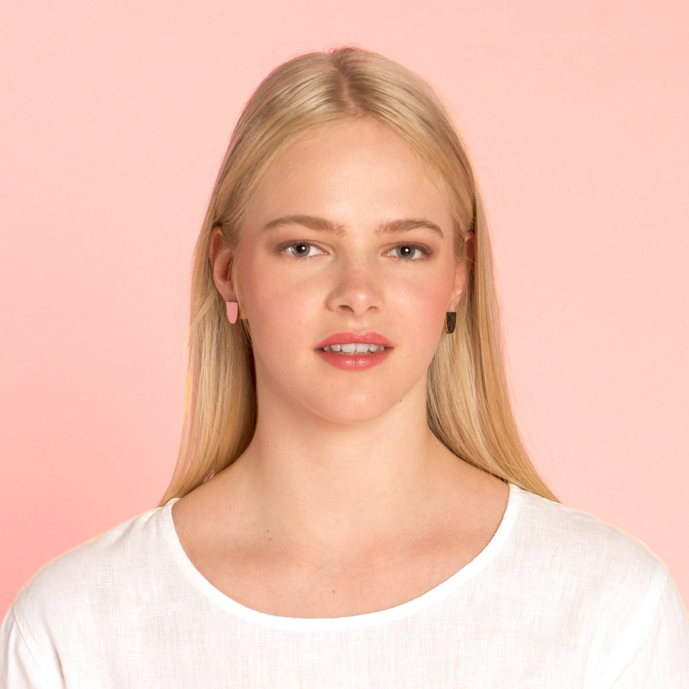 uniste Sokeri mismatched earrings in black and pink birch veneer, handmade in Finland.