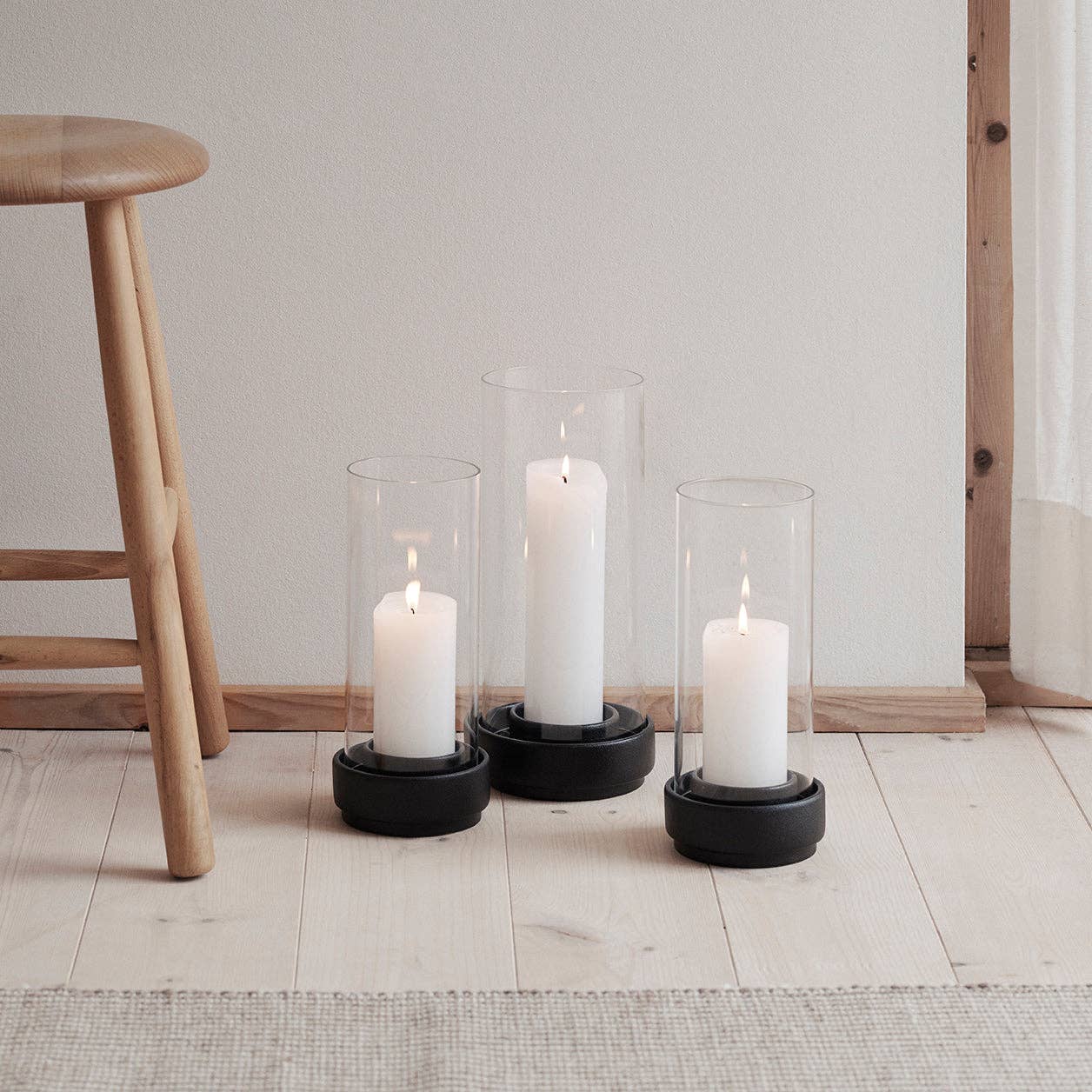 Stelton Hurricane Candle Holders in black or sand stoneware with glass shade, weather-resistant for indoor or outdoor candlelight.