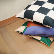 Stack of eco-friendly modern dog beds in checkered pattern, made from Better Cotton™ canvas with recycled PET fill.