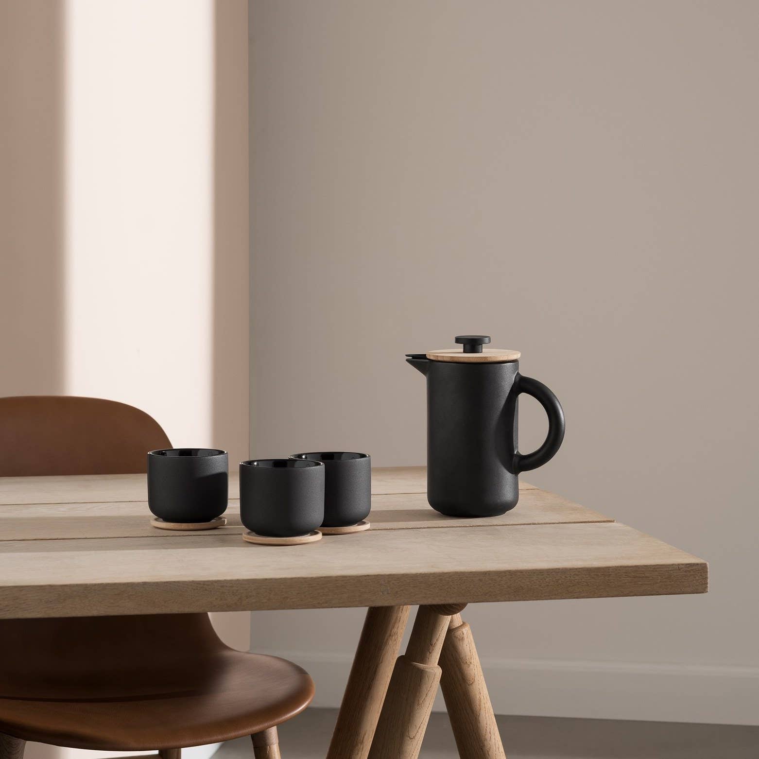 Stelton Theo French Press and coffee cups in matte black stoneware by Francis Cayouette with glossy interior glaze, rustic yet modern Nordic coffee maker, 0.8L capacity.