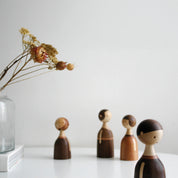 Architectmade Kin figurines by Lars Beller Fjetland, handmade in walnut, mahogany, and maple with tilting heads, shown in a mix-and-match constellation.