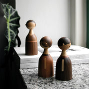 Architectmade Kin figurines by Lars Beller Fjetland, handmade in walnut, mahogany, and maple with tilting heads, shown in a mix-and-match constellation.