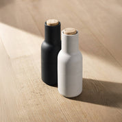Audo Copenhagen Bottle Grinder in bottle-shaped form with beech lid. Minimal Nordic salt and pepper mill with inverted, mess-free design.