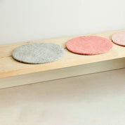 Aveva Seat Cushion in wool felt, available in raw grey or graphic patterns. Round portable chair pads in two sizes, designed in Sweden.