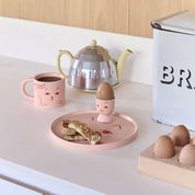 Donna Wilson Cat Mg and Cate Side Plate in candy-pink ceramic with glazed cat face, playful plate for serving snacks or hanging as wall art.