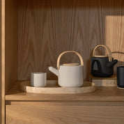 Stelton Theo Thermo Cup with bamboo coaster, available in matte black or sand stoneware with glossy interior, designed by Francis Cayouette. 0.25 L Nordic mug.