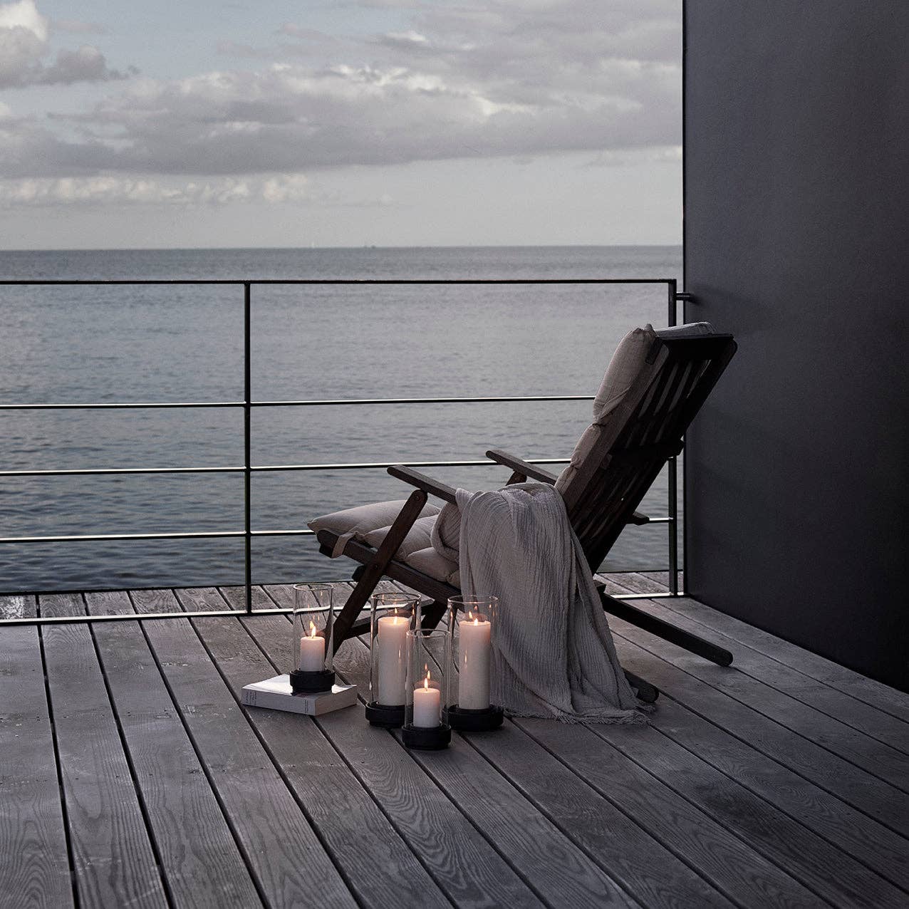 Stelton Hurricane Candle Holders in black or sand stoneware with glass shade, weather-resistant for indoor or outdoor candlelight.