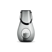 Holmegaard Design With Light H29 mouth-blown glass lantern with full-grain leather strap by Maria Berntsen, available in clear or smoke, 11.4 inches tall.