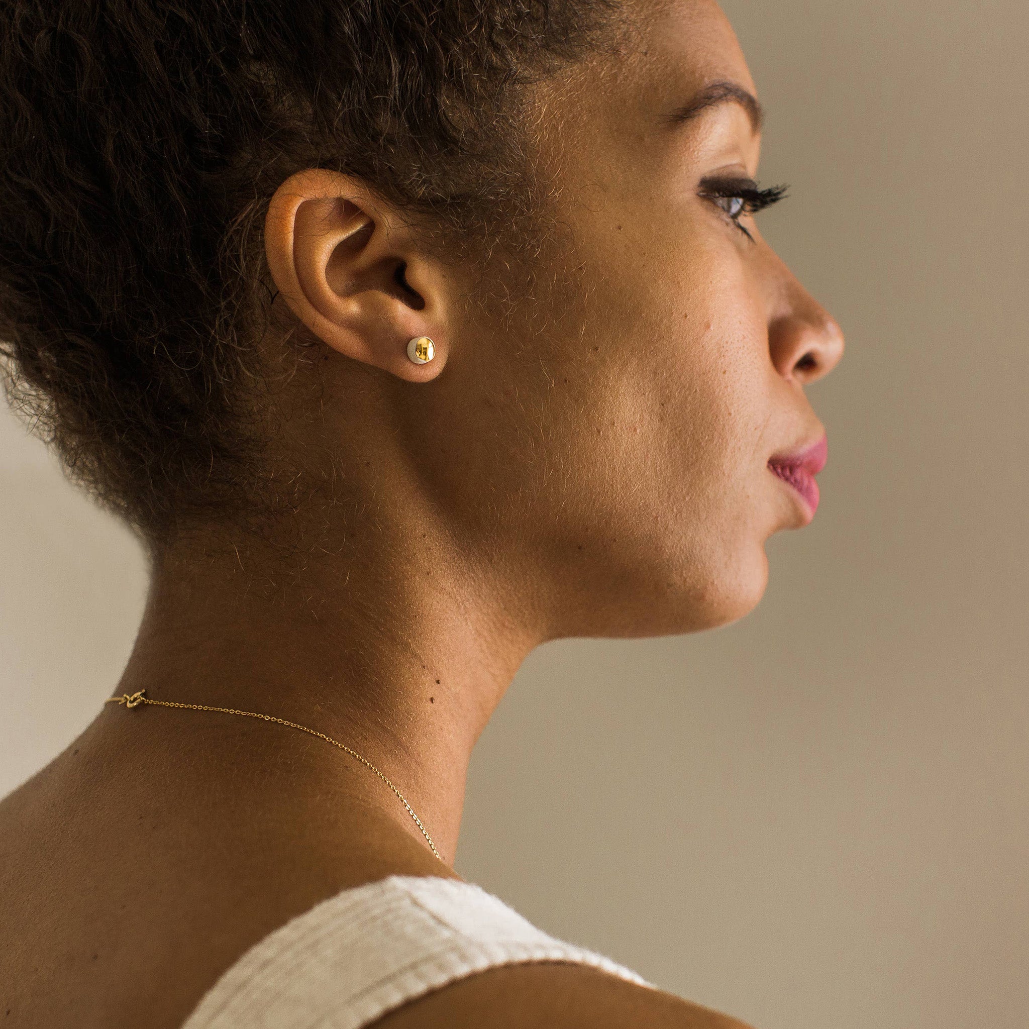 Gold porcelain dot stud earrings handmade by Jenna Vanden Brink, ¼″ shiny luster finish with titanium posts