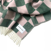 Maison Deux Checkerboard Blanket in green and pink lambswool with bold reversible checkerboard design.