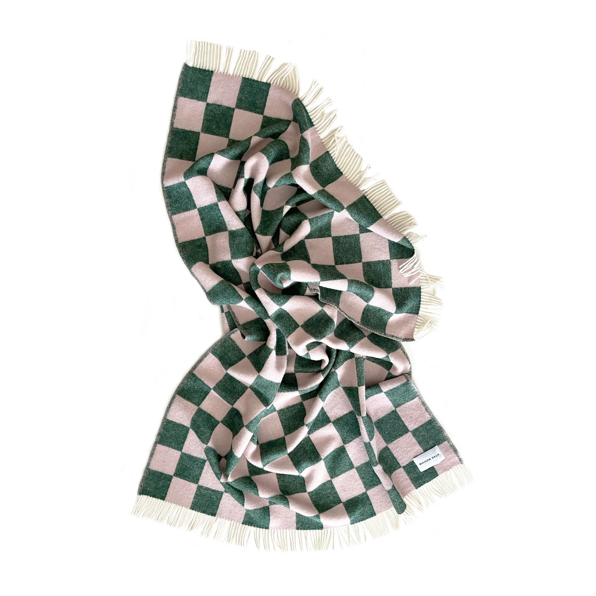 Maison Deux Checkerboard Blanket in green and pink lambswool with bold reversible checkerboard design.