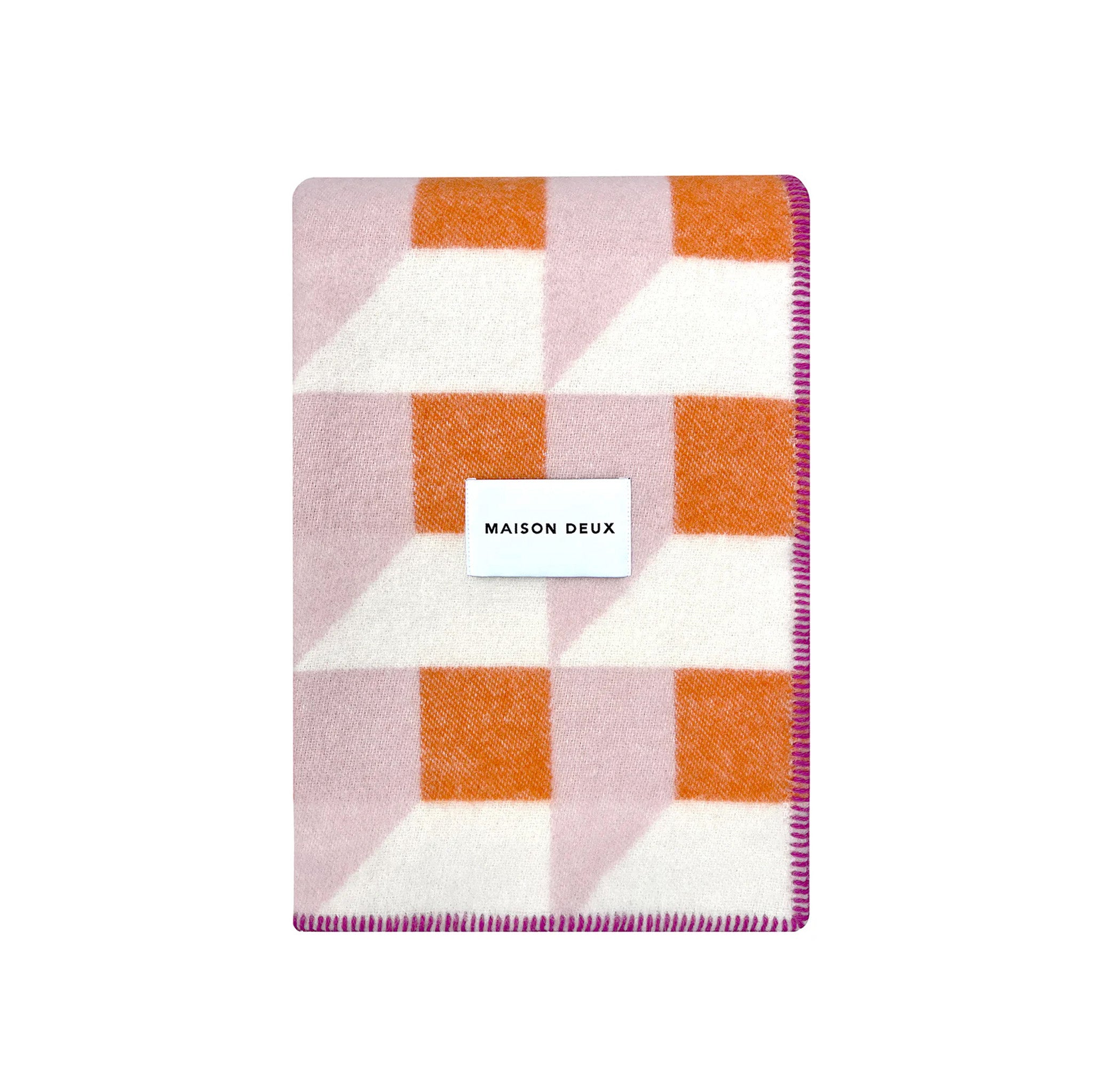 Maison Deux Cubics Blanket in pink and carrot, reversible wool throw with cubic pattern and fringed edges, oversized for cozy lounging.