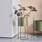 Maki Plant Box in Clay, Nutmeg, or Olive with rattan handles, shown in Low and High versions.