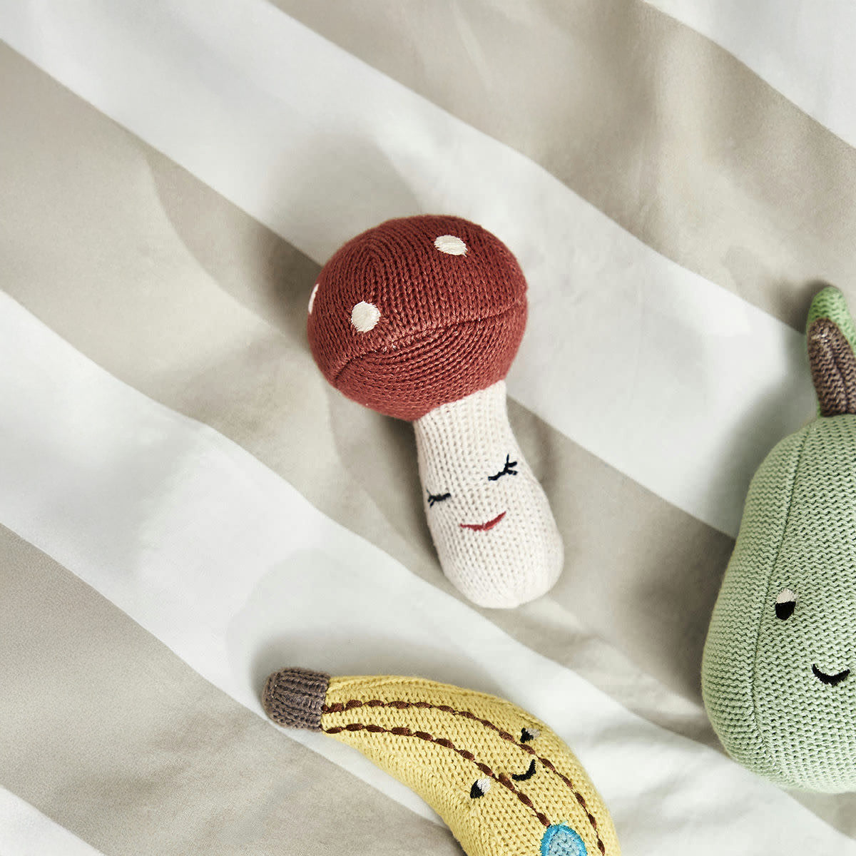 OYOY Living Design Mushroom Rattle in OEKO-TEX cotton, rosy red cap with white dots and embroidered sleepy face, eco-friendly baby toy.