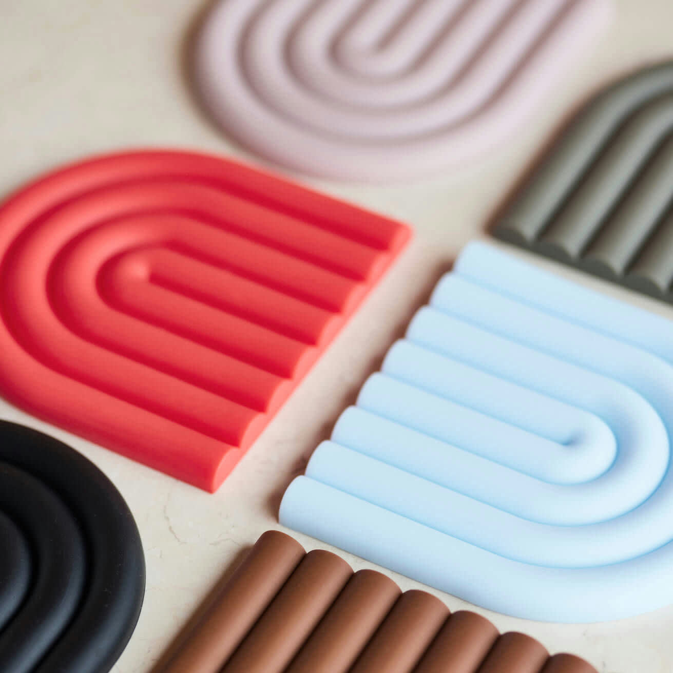 OYOY Living Design Rainbow Trivet in silicone with rainbow arc design. Heat-safe, wipe-clean trivet, designed in Denmark.