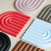 OYOY Living Design Rainbow Trivet in silicone with rainbow arc design. Heat-safe, wipe-clean trivet, designed in Denmark.