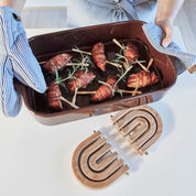 OYOY Living Design Rainbow Wooden Trivet in oak with brass details. Foldable rainbow shape expands for hot pots or hangs as wall décor.