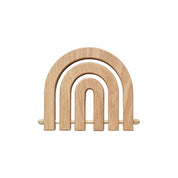 OYOY Living Design Rainbow Wooden Trivet in oak with brass details. Foldable rainbow shape expands for hot pots or hangs as wall décor.