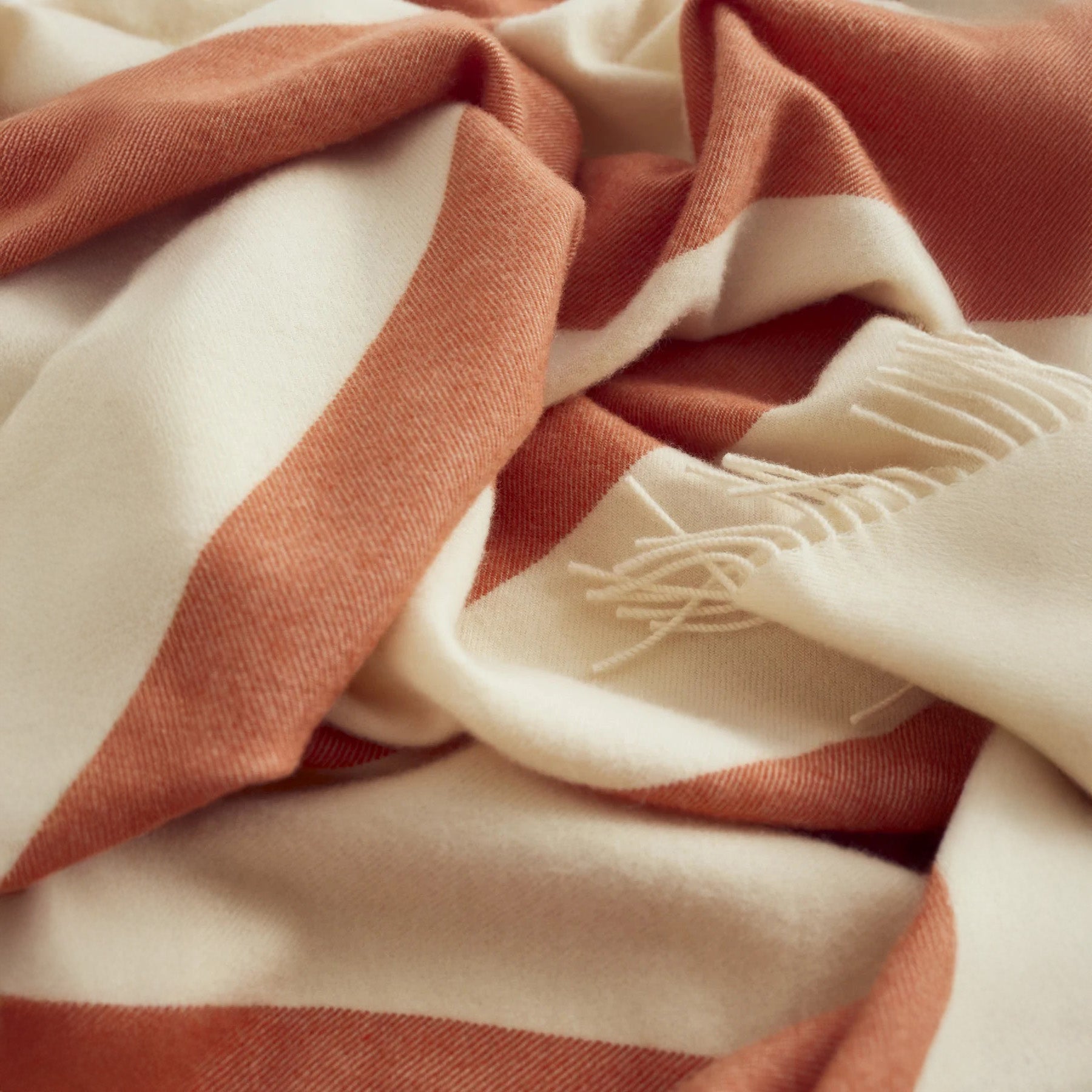 Stilleben Sweater Throw in orange 100% combed wool with tone-on-tone stripes.