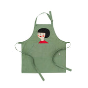 Kerstin Kompisförkläde Apron by Spira of Sweden. Hand-printed cotton apron featuring Kerstin, the dahlia-dreaming flower lover. Gift-boxed, machine washable, OEKO-TEX® certified, 29.5" × 32.5", made in Sweden.