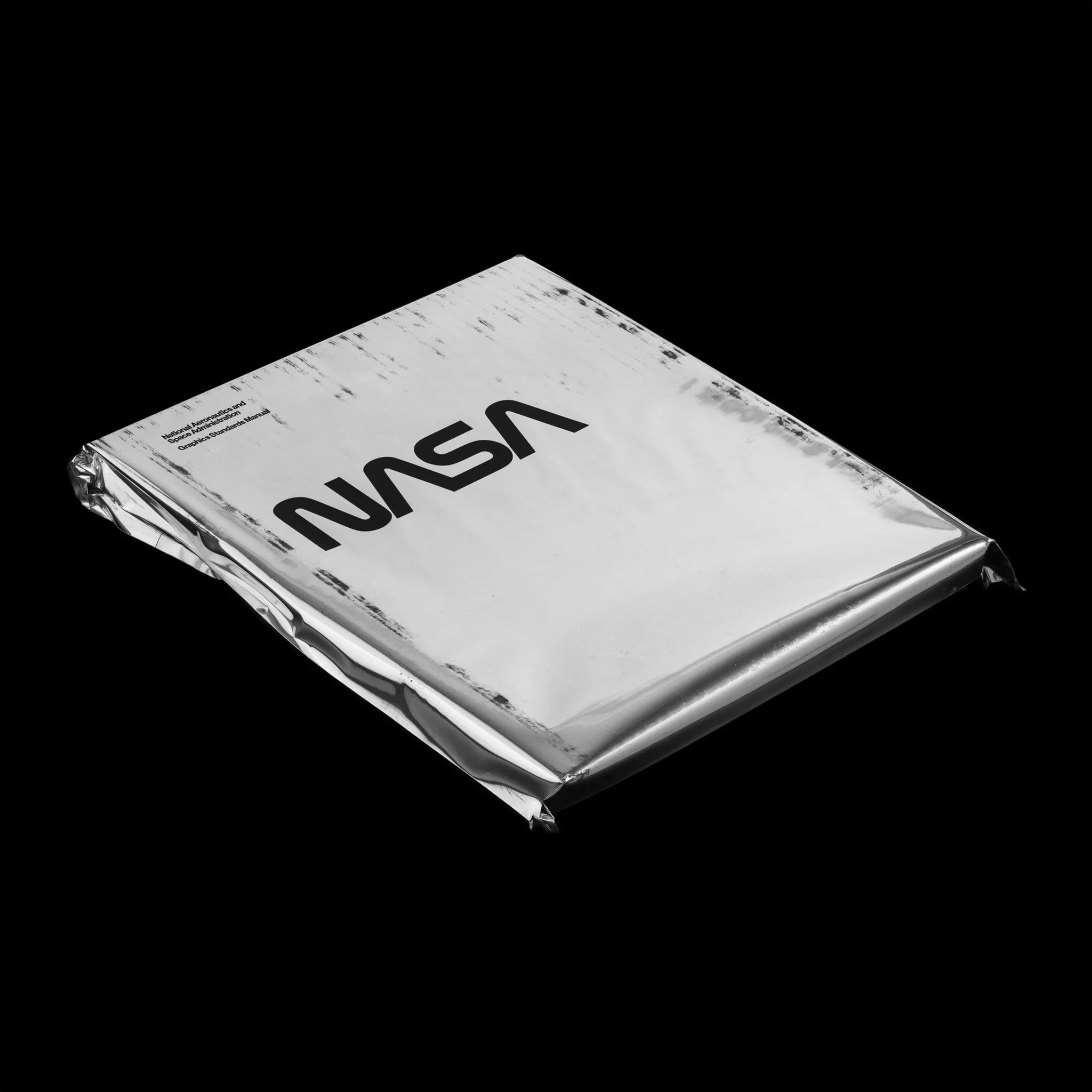 NASA Graphics Standards Manual book — case-bound with silkscreen cover, reproducing Danne & Blackburn’s 1975 design system with original scans and essays.