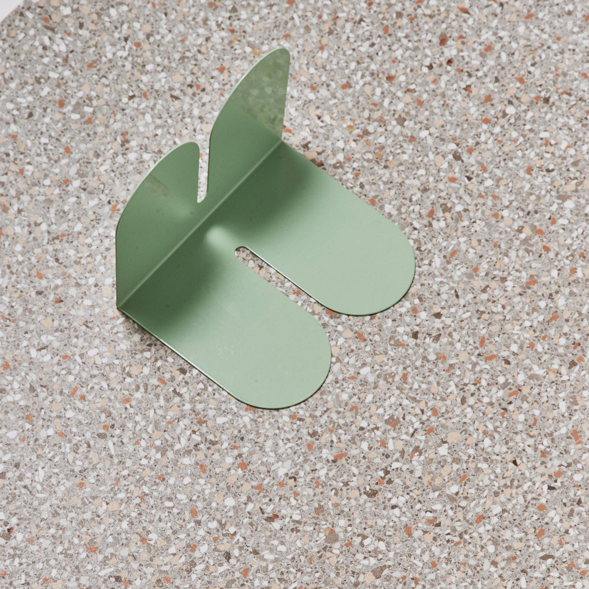 Tortuga Forma Large Bookend in cactus green solid steel, oversized arc design for supporting art books, cookbooks, or vinyl.