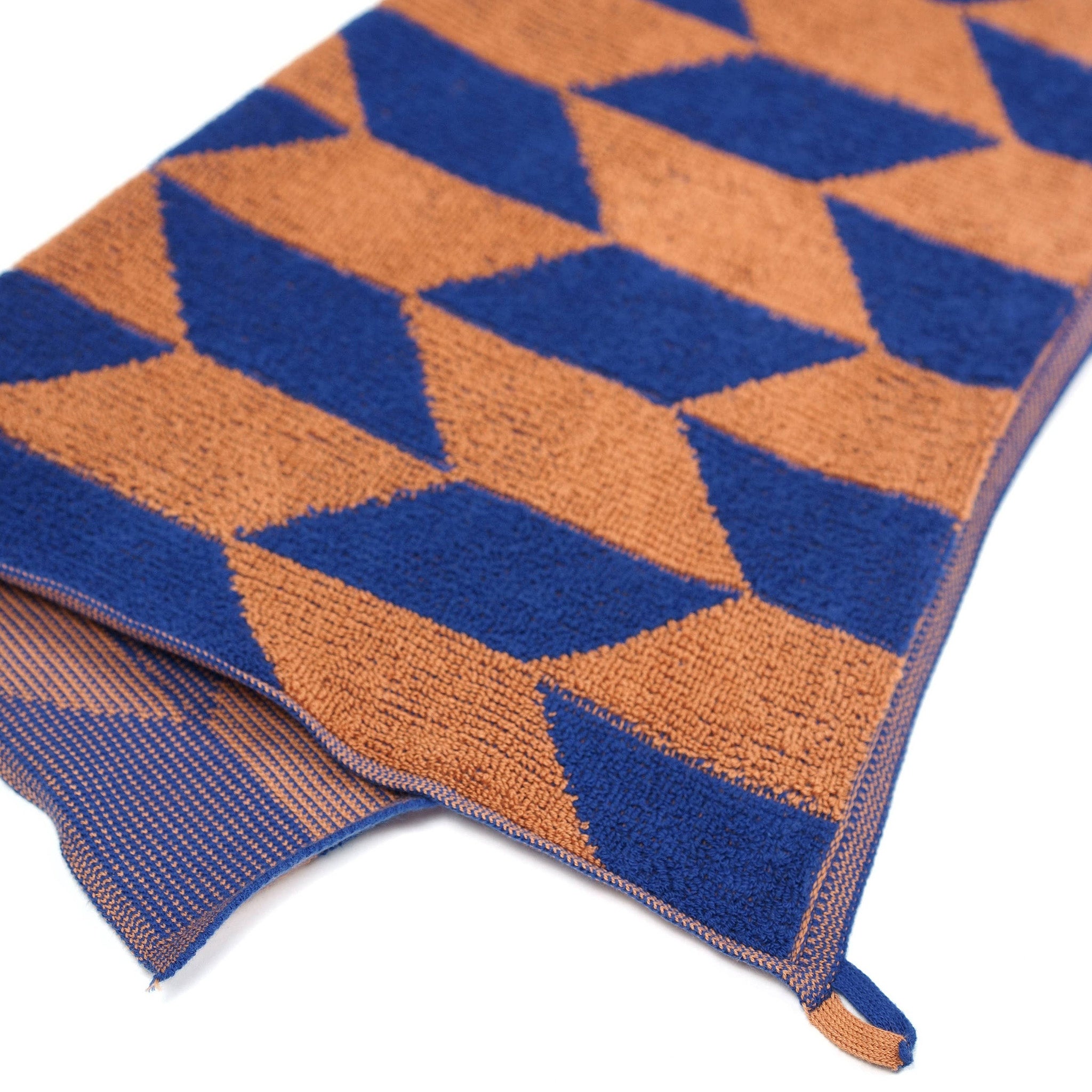 Towel Studio Arrow Tail Guest Towel in Azure and Chestnut, 50 × 50 cm with terry front and knit back.