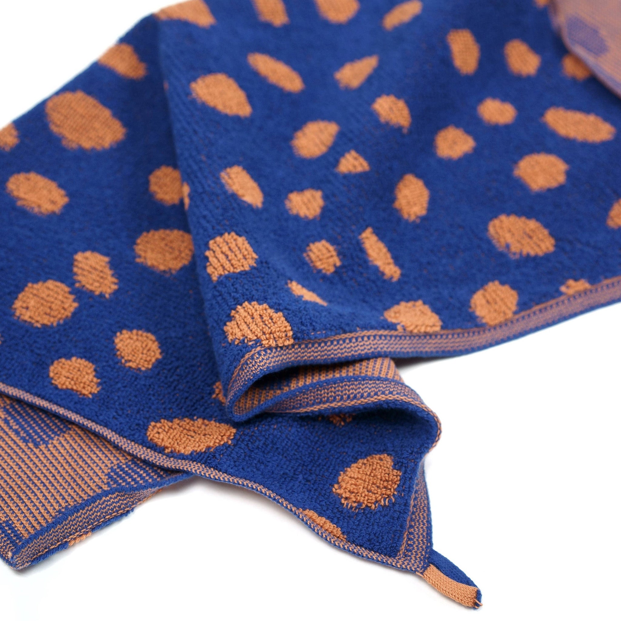 Pebbles Guest Towel by Towel Studio in Azure Blue and Chestnut Brown, 50 × 50 cm with terry front and knit back.