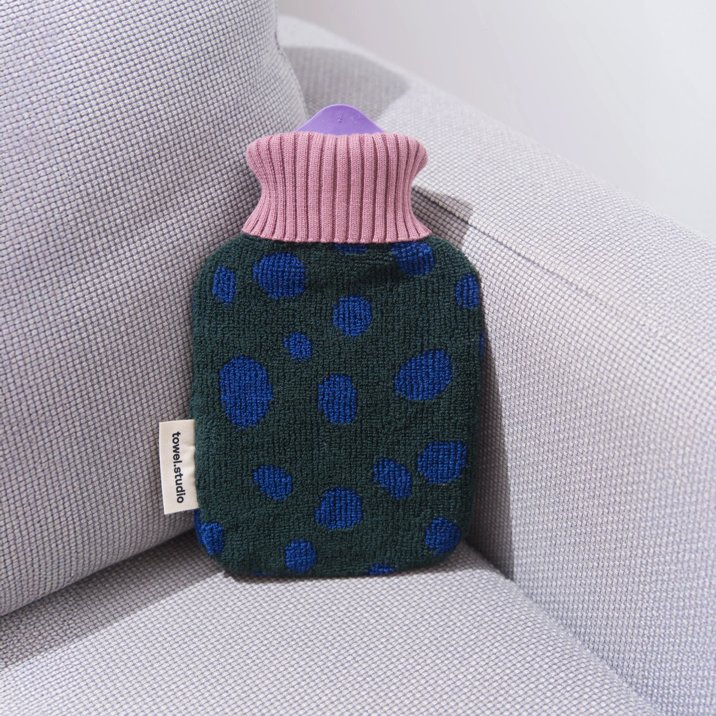 Pebbles Hot Water Bottle by Towel Studio, small 0.8 L. Grapevine green terry cover with blue pebble pattern and lavender ribbed collar, organic cotton with natural rubber bottle.